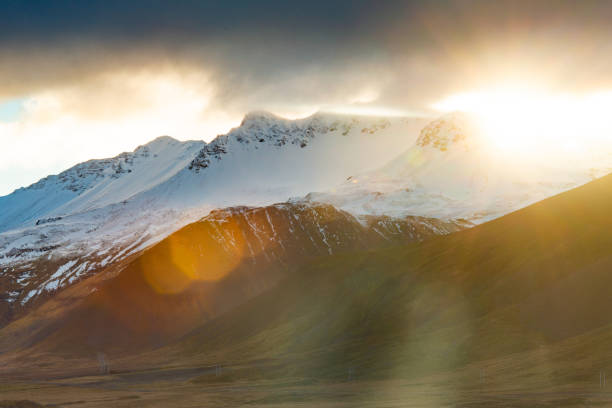 This is a scenic view of the sun over the mountains in Snaefellsnes Iceland.