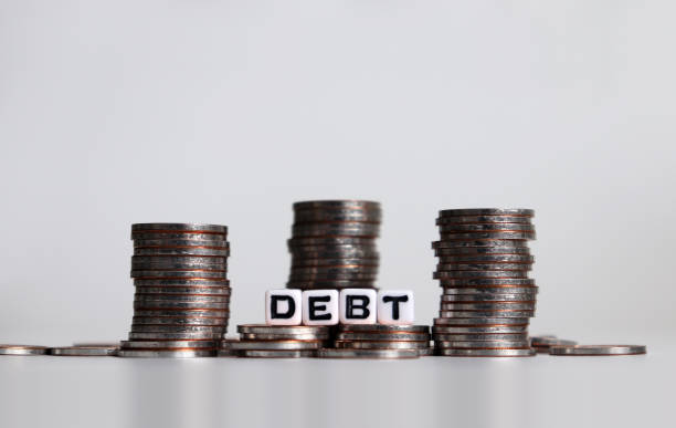 istock Alphabet cube with DEBT text on white background. Cube and coins. 1131948777