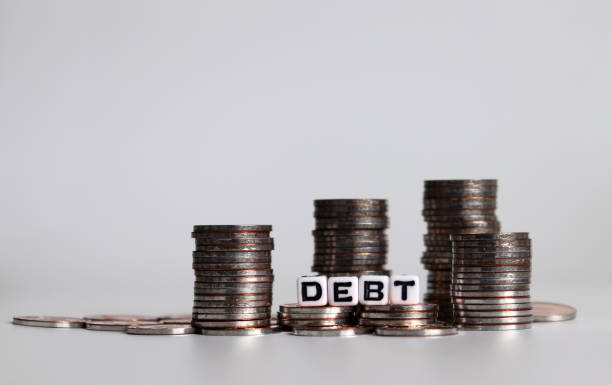 istock Alphabet cube with DEBT text on white background. Cube and coins. 1131949024
