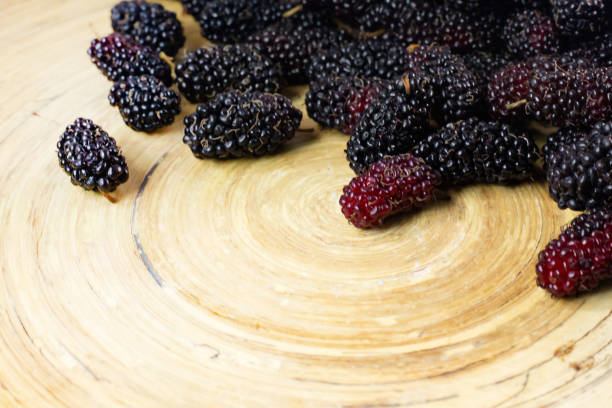 istock The mulberry fruit in white bowl on wood table. 1131949354