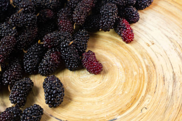 istock The mulberry fruit in white bowl on wood table. 1131949393