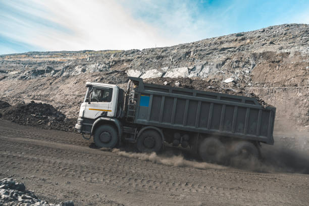 istock Large quarry dump truck. Loading the rock in dumper. Loading coal into body truck. Production useful minerals. Mining truck mining machinery, to transport coal from open-pit as the Coal Production 1131949980