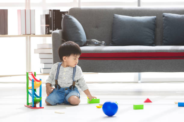 istock Asian kid playing in living room 1131952601
