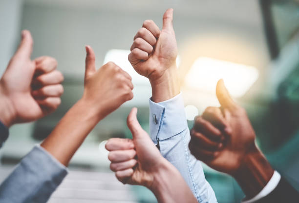 Keep up the amazing work! Cropped shot of a group of unrecognizable businesspeople showing thumbs up in an office dedication stock pictures, royalty-free photos & images