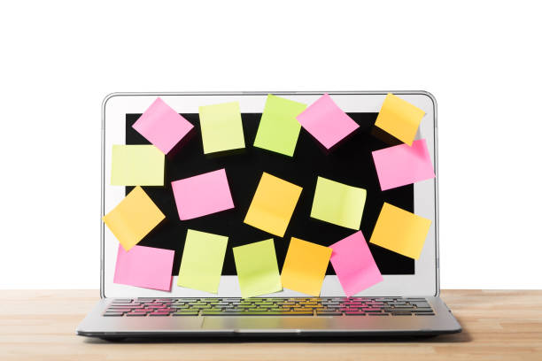 istock Many blank sticky notes covering a laptop screen on wooden table against isolated white background. Concept of deadlines or ideas. 1131955548