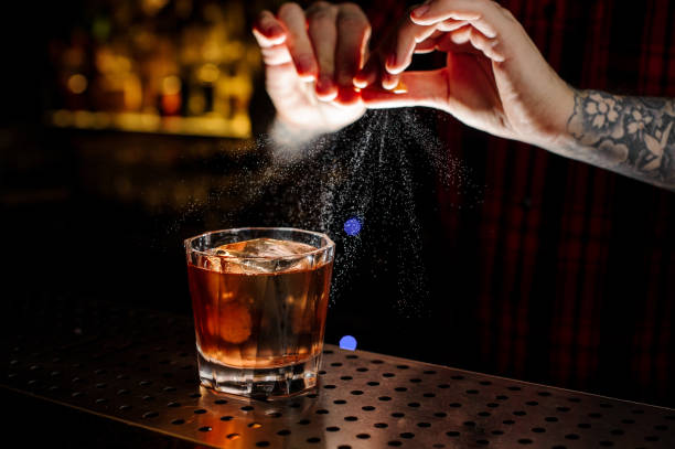 istock Barman adding orange zest juice to a Foreign Legion cocktail 1131959836