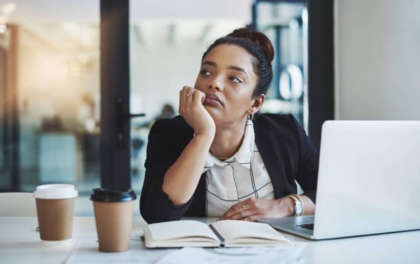 Maybe I'm not meant for a desk job Shot of a young businesswoman looking bored while working at her desk in a modern office sulking stock pictures, royalty-free photos & images