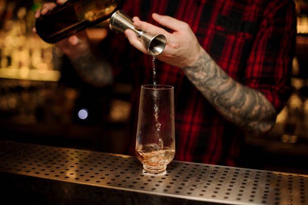 istock Bartender pouring a Trinidad Swizzle cocktail from the steel jigger 1131960137