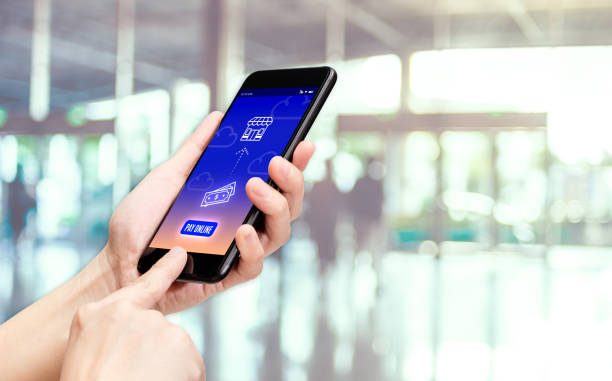 istock Hand holding mobile with pay word and bill icon feature with blur back office counter background,Digital Lifestyle concept. 1131960184