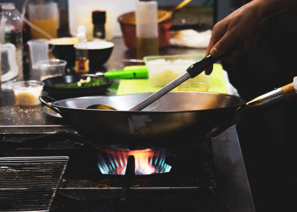 istock Chef cooking food in the kitchen, stir fried vegetables in the pan 1131962097