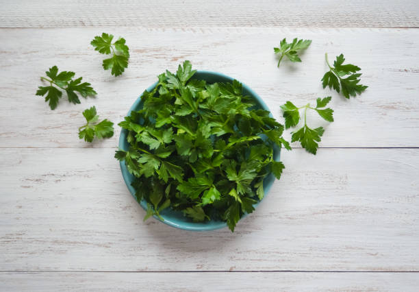 istock Fresh parsley flat lay on a white wooden table. 1131965426