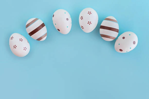 istock Eggs decorated with stripes and flowers on pasel blue background. 1131968397
