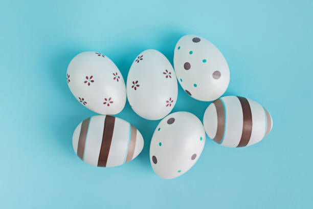 istock Eggs decorated with stripes and flowers on pasel blue background. 1131968422