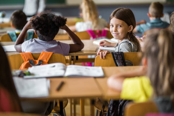 istock Smiling schoolgirl attending a class in the classroom. 1131970037