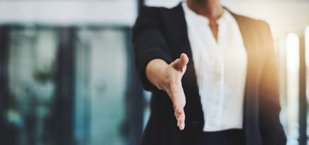 Welcome to the best company in the business Cropped shot of an unidentifiable businesswoman extending her arm for a handshake global business handshake stock pictures, royalty-free photos & images