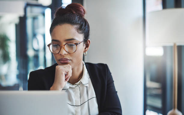 Nothing gets it done like focus and dedication Shot of a young businesswoman using a laptop in a modern office grave stock pictures, royalty-free photos & images