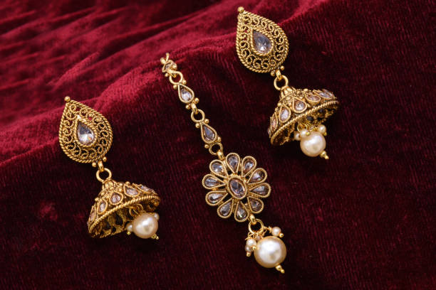 необычные дизайнер золотые серьги крупным планом макро изображение на красном фоне - earring gold jewelry contemporary стоковые фото и изображения