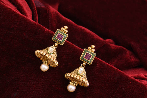 ファンシーデザイナー黄金のイヤリングクローズアップマクロ画像赤の背景 - antique traditional culture earring pair ストックフォトと画像