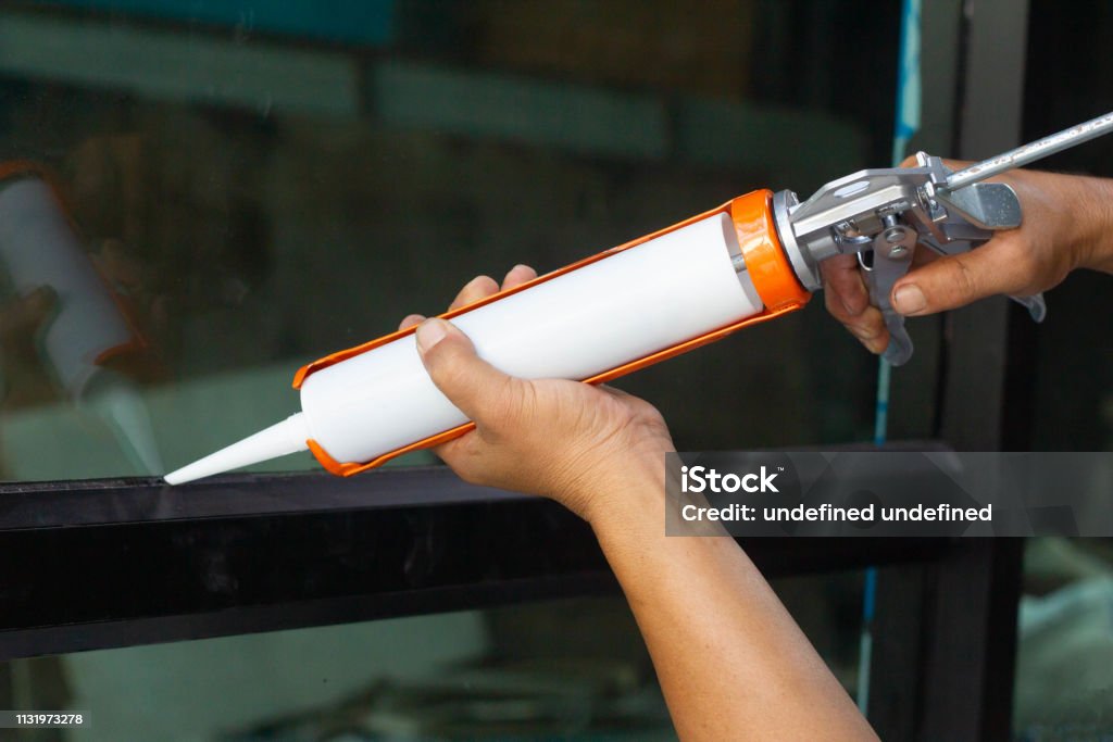The Craftsmans Hand Uses Silicone Glue And Glue To Weld The Glass And  Aluminum Stock Photo - Download Image Now - iStock