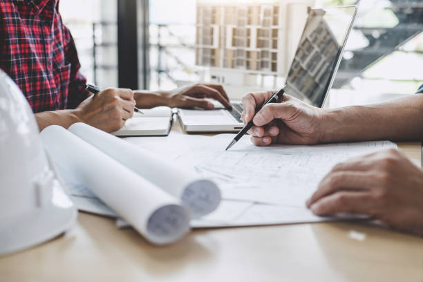 istock Hands of architect or engineer working on blueprint meeting for project working with partner on model building and engineering tools in working site, Construction and structure concept 1131976012