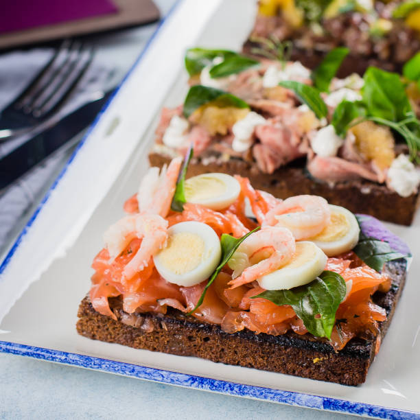 set von skandinavischen snack. smorrebrod. traditionelle dänische offene sanwiches, dunkles roggenbrot mit unterschiedlichem topping - sandwich avocado prepared shrimp bread stock-fotos und bilder