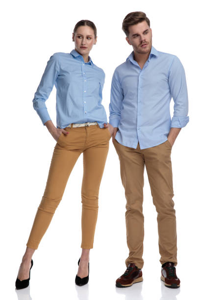 relaxed couple with hands in pockets looking to side,