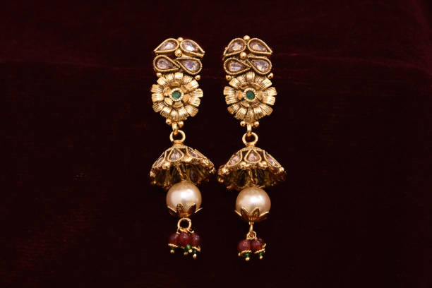 ファンシーデザイナー黄金のイヤリングクローズアップマクロ画像赤の背景 - antique traditional culture earring pair ストックフォトと画像