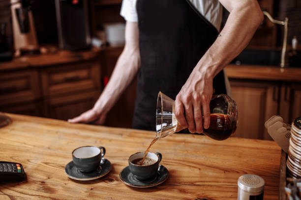 istock waiter is pouring ground coffee in the cups for visitors 1131981136
