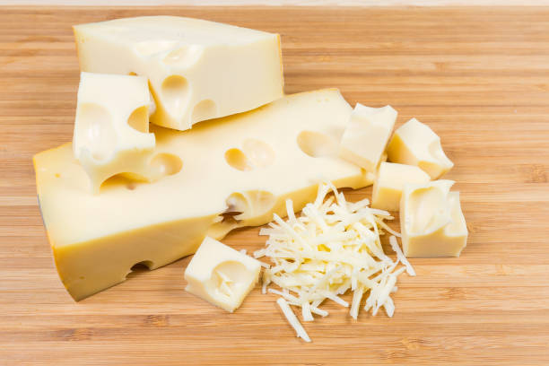 istock Partly sliced and grated Swiss-type cheese on cutting board 1131981866