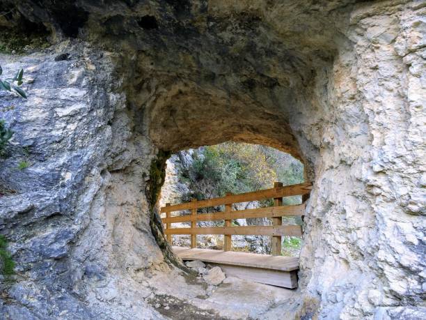 un sentiero attraverso un buco in un muro di roccia, nel percorso dei seimila gradini, a barranc de lâinfern, il burrone di hellâs, a orba e vall de laguar, alicante, spagna - stairway to hell foto e immagini stock