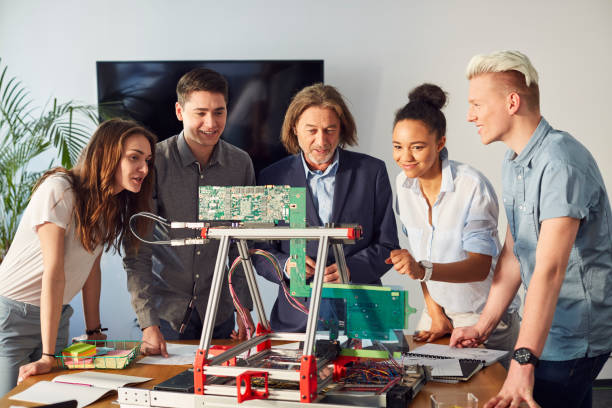 istock Young team testing new device with mentor. Startup company 1131983543