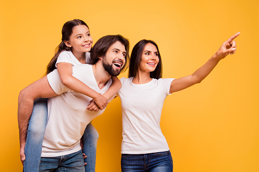 Portrait of nice cute sweet lovely attractive adorable charming cheerful dreamy people mom dad pre-teen girl looking far away isolated over shine vivid pastel yellow background.