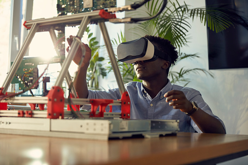 Young African ethnicity man designing device. Virtual reality simulation