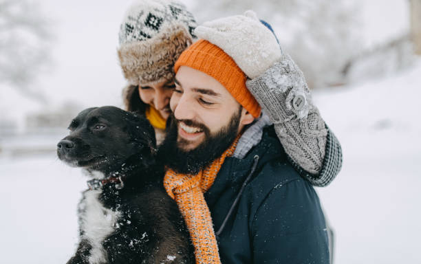 istock Couple in the snow play with dog 1131985033
