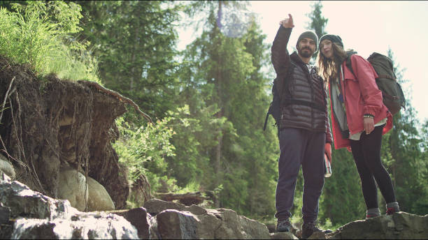 istock Young man pointing travel direction. Couple on a hike 1131985902