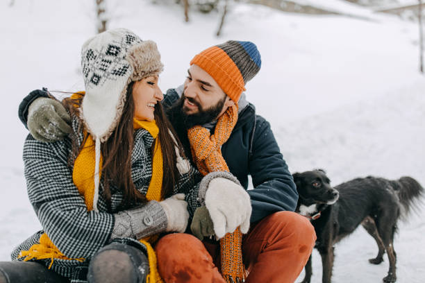 istock Couple in the snow play with dog 1131986571