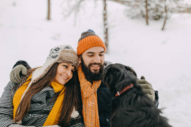 istock Couple in the snow play with dog 1131986573