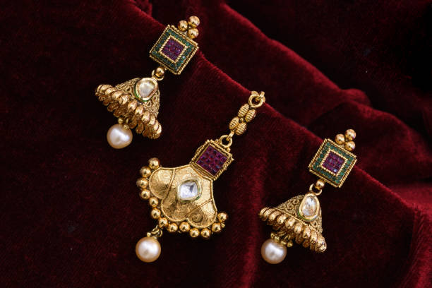 ファンシーデザイナー黄金のイヤリングクローズアップマクロ画像赤の背景 - antique traditional culture earring pair ストックフォトと画像