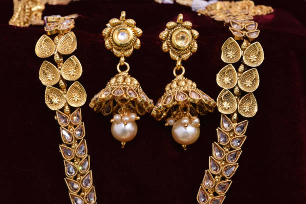 フ��ァンシーデザイナー黄金のイヤリングクローズアップマクロ画像赤の背景 - antique traditional culture earring pair ストックフォトと画像