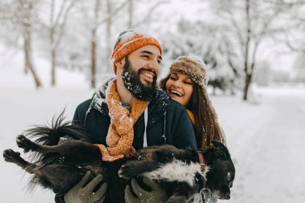 istock Couple in the snow play with dog 1131988693