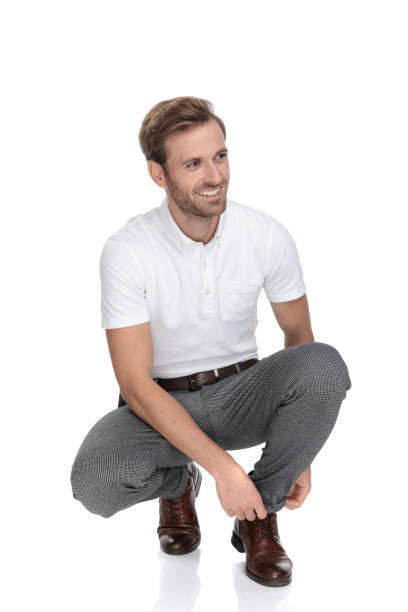 istock smiling casual man tying his shoes while crouched 1131989302