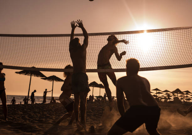 istock Young friends having fun while playing beach volleyball at sunset. 1131992614
