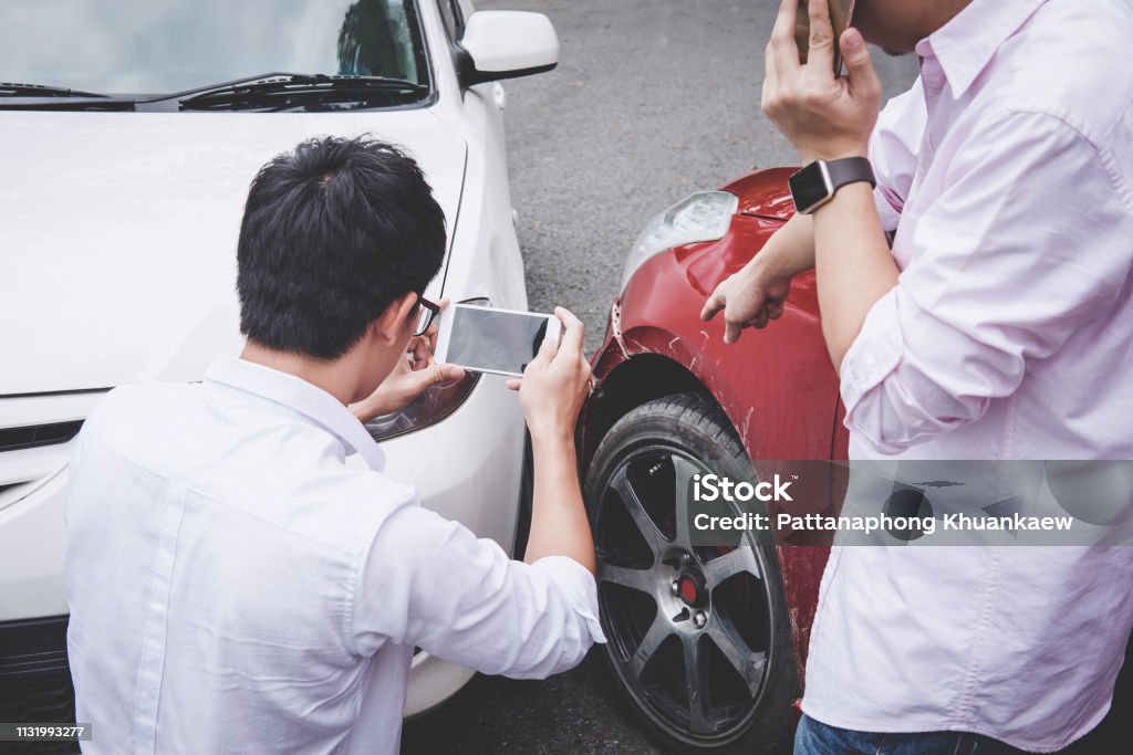 Two drivers man arguing after a car traffic accident collision and making phone call to Insurance Agent and take a photo, Traffic Accident and insurance concept Two drivers man arguing after a car traffic accident collision and making phone call to Insurance Agent and take a photo, Traffic Accident and insurance concept. Car Accident Stock Photo