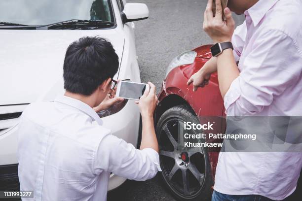 Two Drivers Man Arguing After A Car Traffic Accident Collision And Making Phone Call To Insurance Agent And Take A Photo Traffic Accident And Insurance Concept Stock Photo - Download Image Now
