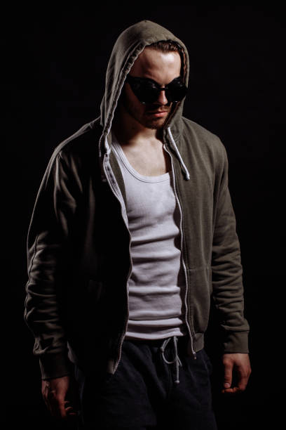 man in hoodie and glasses hanging head down. keep head down. depression. anger. melancholy. guilty.