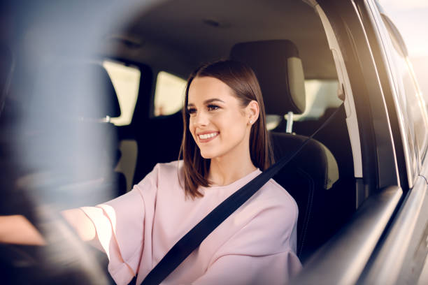 portret piękna z zębatym uśmiechem jazdy samochodem. ręce na kierownicy. - people behavior smiling mode of transport zdjęcia i obrazy z banku zdjęć