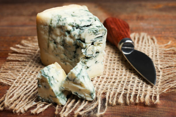 Blue cheese, Dor Blue and knife for slicing cheese on wooden background.