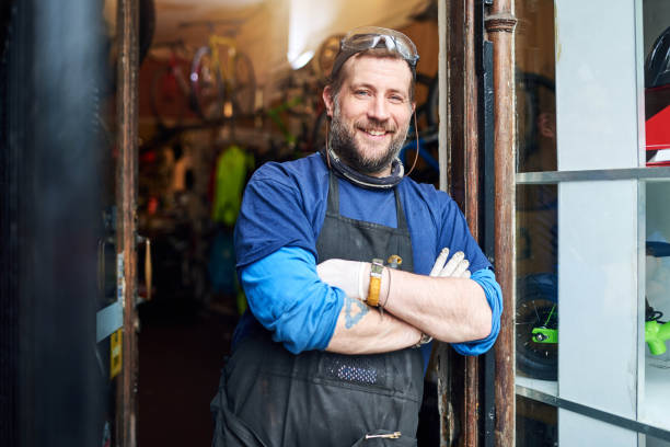 My store has become one of the best in town Shot of a handsome man standing outside of his self-owned bicycle shop door repairman men manual worker stock pictures, royalty-free photos & images