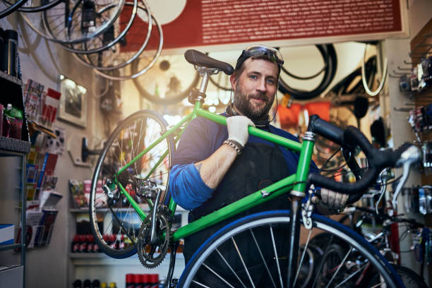 I couldn't imagine a better career for me Shot of a handsome man working in his self-owned bicycle workshop bicycle shop stock pictures, royalty-free photos & images