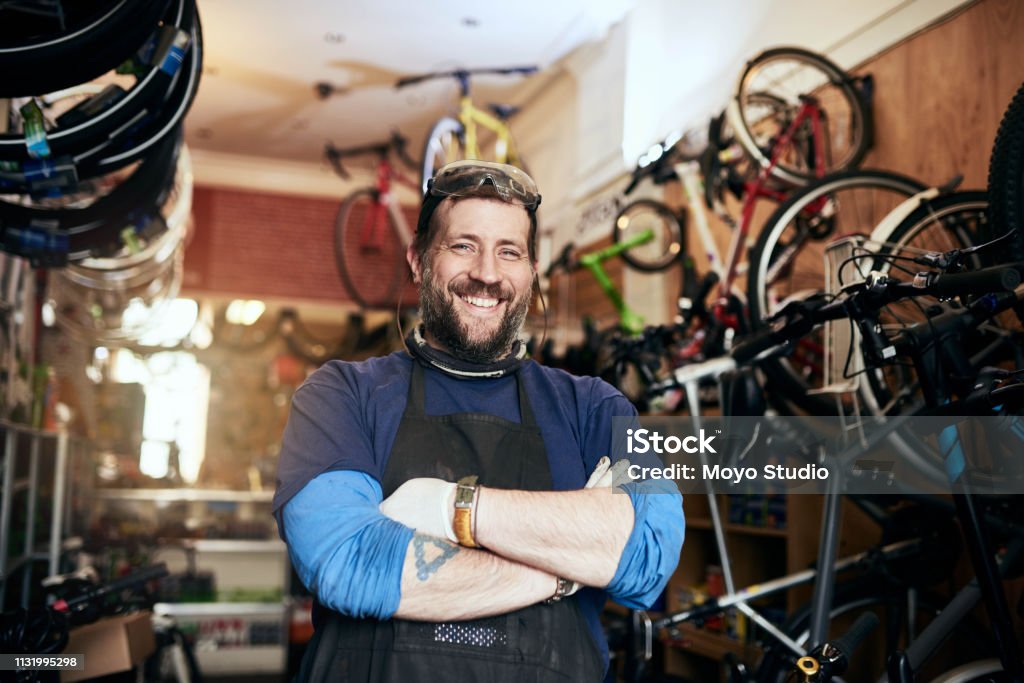 Bring all your bike repairs and maintenance jobs to me Shot of a handsome man working in his self-owned bicycle workshop Owner Stock Photo